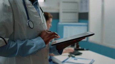 Dokunmatik ekranlı tablet kullanan Afrikalı Amerikalı doktoru kapatın.