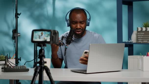 Vlogger lendo más notícias na câmera e segurando smartphone — Vídeo de Stock