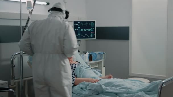 Paciente com coronavírus conversando com médico em traje protetor — Vídeo de Stock