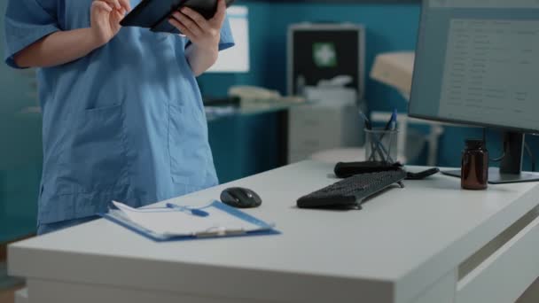 Biała pielęgniarka z tabletem cyfrowym z ekranem dotykowym — Wideo stockowe