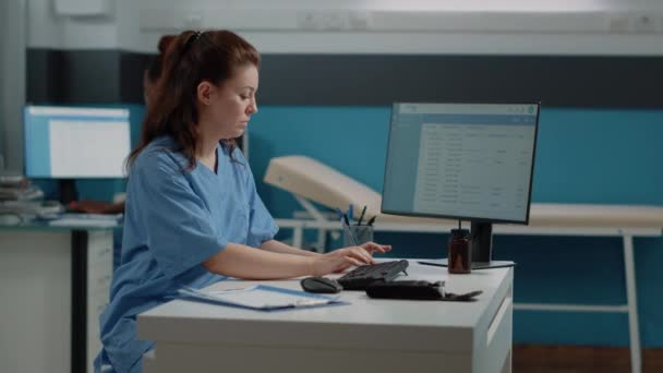 Lékařská asistentka pracující na počítači s informacemi o pacientech — Stock video