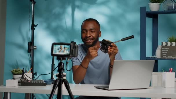 Vlogger κρατώντας κεφαλή τρίποδα για σύσταση στην κάμερα — Αρχείο Βίντεο