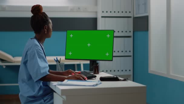 Asystent medyczny korzystający z poziomego zielonego ekranu na komputerze — Wideo stockowe