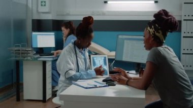 Radyografiye bakan Afrikalı Amerikalı hasta ve doktor