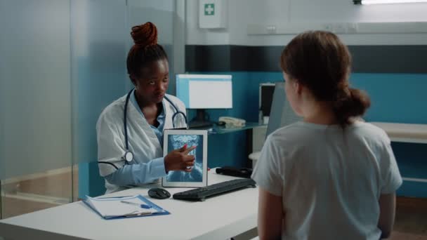 Lékařský specialista ukazuje na rentgen na tabletu pro kontrolu — Stock video