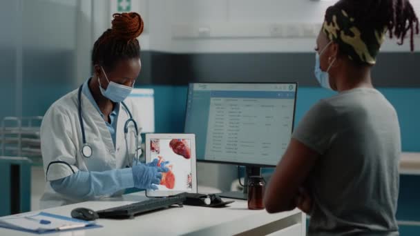 Lekarz wskazujący na tabletkę z narządem serca na ekranie — Wideo stockowe