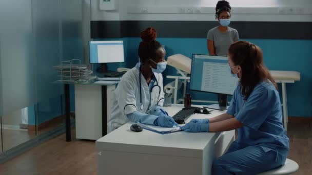 Lékař a sestra pracují s předpisovým dokumentem pro pacienta — Stock video