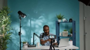 Ürünü incelemek için elinde video gözlüğü tutan Afrikalı Amerikalı bir vlogger.