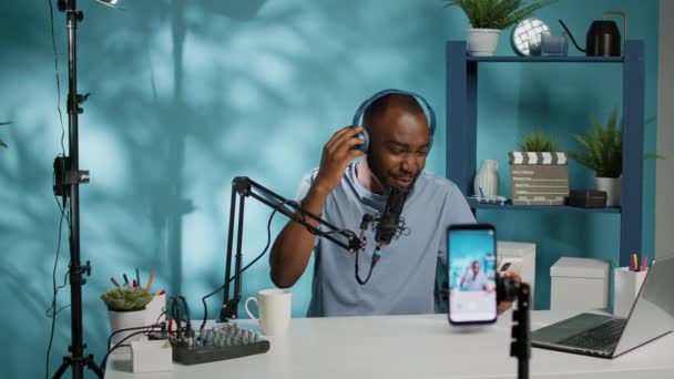 Siyah vlogger stüdyoda akıllı telefondan podcast çekiyor. — Stok video