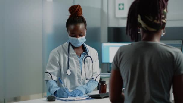 Afrikanischer amerikanischer Arzt bereitet Rezeptpapier vor — Stockvideo