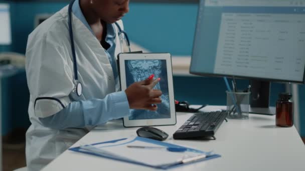 Primer plano del médico apuntando a la pantalla de la tableta con radiografía — Vídeos de Stock