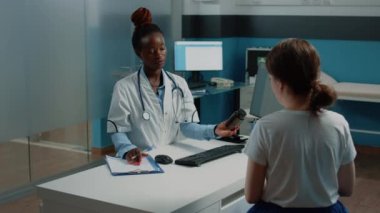 Sağlık görevlisi, check-up 'ta hasta olan hastaya bir şişe hap veriyor.