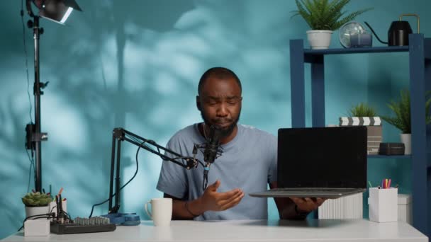 Blogger afroamericano haciendo reseña de producto de laptop — Vídeos de Stock