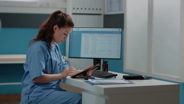Assistente médico trabalhando com computador e tablet digital — Vídeo de Stock