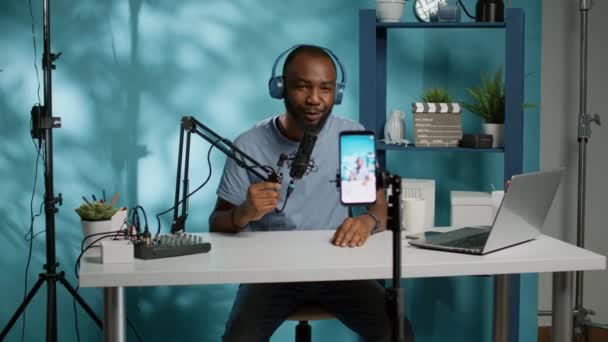 Vlogger afroamericano usando smartphone para filmar podcast — Vídeos de Stock