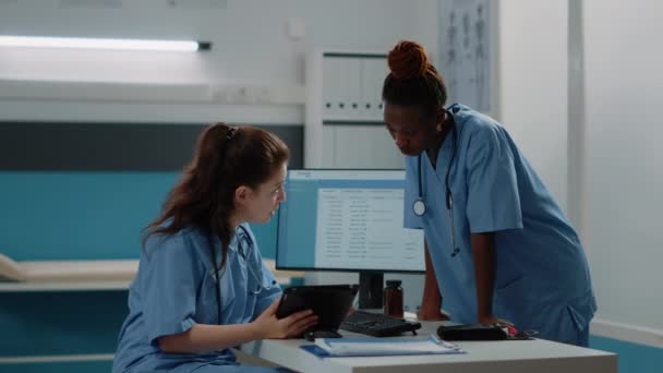 Multietnický tým zdravotních sester se dívá na digitální tablet — Stock video