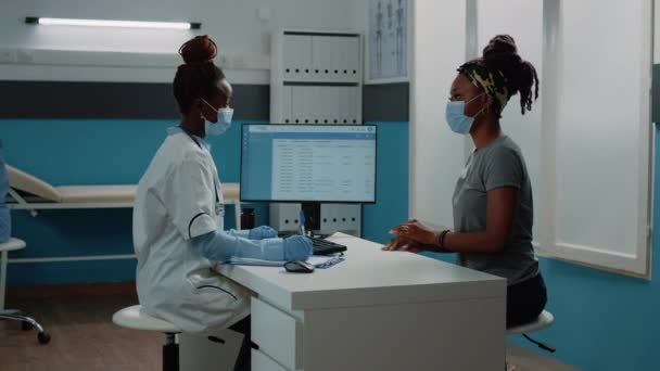 Médico y paciente con mascarillas que analizan el escaneo de rayos X — Vídeos de Stock