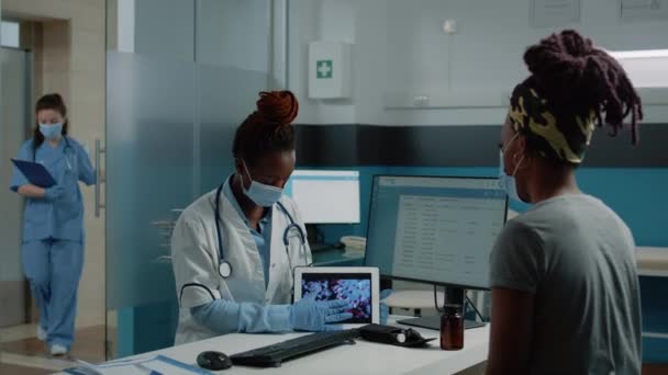 医生在平板电脑上向病人展示病毒动画 — 图库视频影像