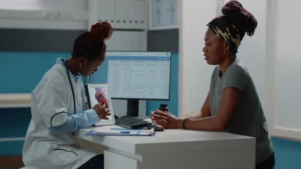 Arzt zeigt auf Tablette mit Herz-Kreislauf-Figur — Stockvideo