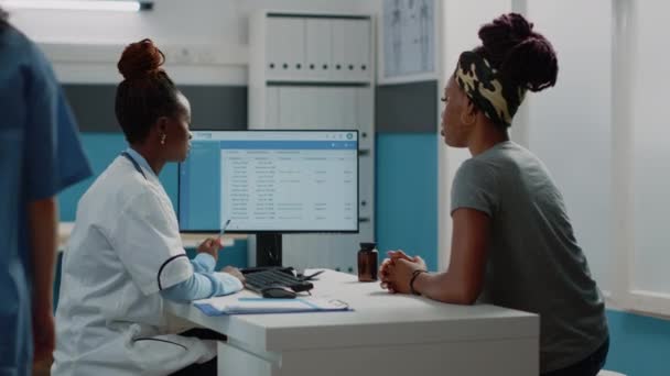 Médico y mujer afroamericanos mirando la pantalla de la computadora — Vídeos de Stock