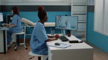 Hemşire kabinede doktorla görüntülü konuşma yapıyor.