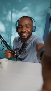 Dikey video: Stüdyoda video çekmek için kamera tutan vlogger POV