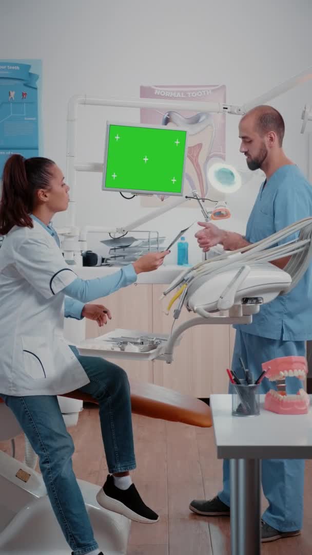 垂直录像：牙科医生和护士分析牙齿X光和说话 — 图库视频影像
