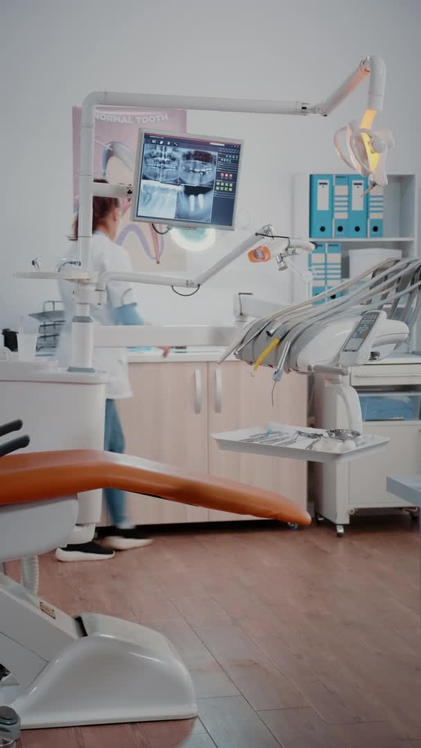 Vertical video: Woman dentist preparing stomatology chair — Stock Video