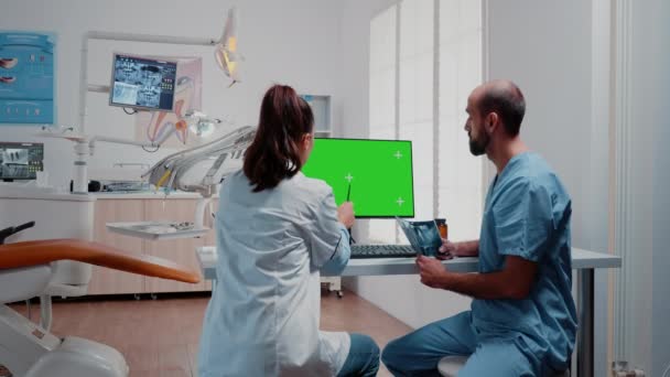 Zespół stomatologiczny analizuje promienie rentgenowskie zębów i zielony ekran na monitorze — Wideo stockowe