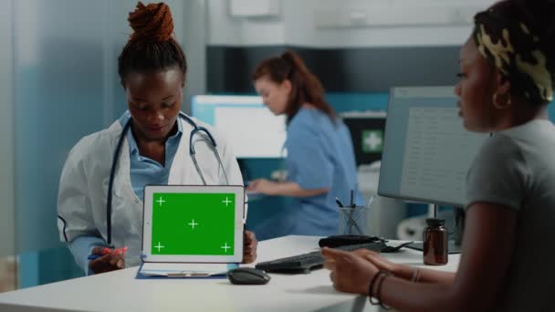女性医師は、水平方向の緑の画面とタブレットを指して — ストック動画