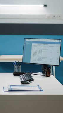 Tıbbi ekipman ve bilgisayarı olan boş bir doktor ofisi.