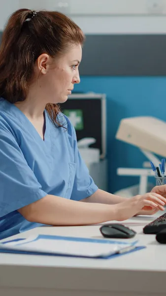 Infirmière tapant sur le clavier de l'ordinateur pour consultation — Photo