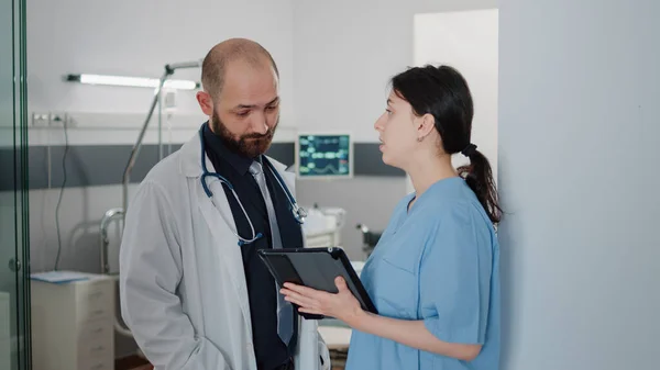医生和护士用平板电脑谈论病人的治疗 — 图库照片