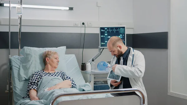 Ιατρός κρατώντας δισκίο με ακτινογραφία για εξέταση υγειονομικής περίθαλψης — Φωτογραφία Αρχείου