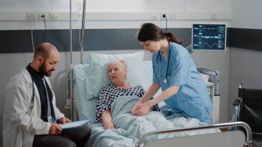 Doktor ve hemşire emekli bir hastayla görüşüyor.