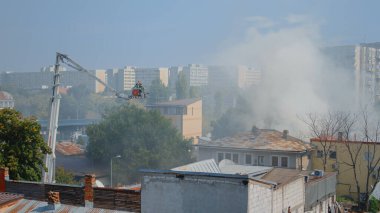 Platform kamyonunda itfaiyeciler çatıya çıkmak için bekliyorlar.