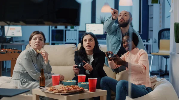 Різноманітна група людей, які грають у відеоігри на телевізійній консолі — стокове фото