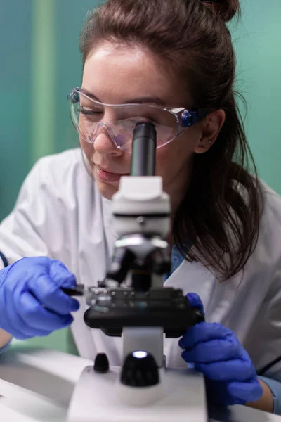 Ritratto di ricercatrice microbiologa che analizza il campione di foglie di OGM al microscopio medico — Foto Stock