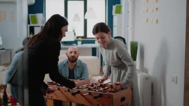 Colleagues playing foosball game and woman winning — Stock Video