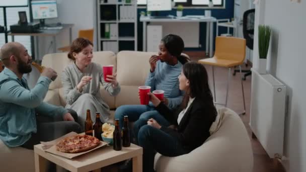 Весёлые коллеги пьют алкогольные напитки после работы в офисе — стоковое видео