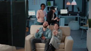 İş arkadaşları TV 'de oyun oynayarak eğleniyorlar.