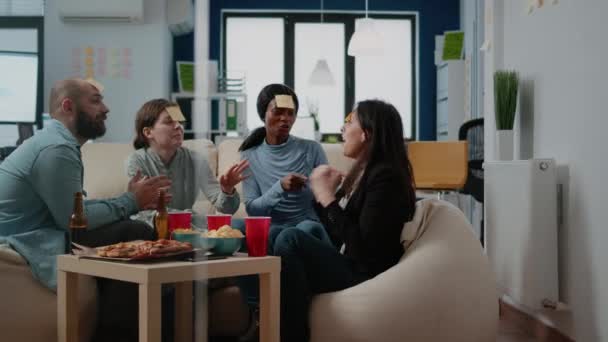 Spolupracovníci hrají šarády hru s lepkavé poznámky po práci — Stock video