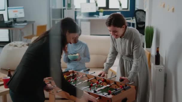 Vállalati munkatársak segítségével csocsó asztal játszani foci játék — Stock videók