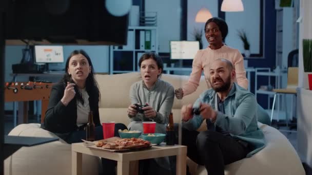 Щасливі колеги, які грають у відеоігри після роботи в офісі — стокове відео