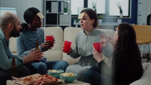 Compañeros alegres juegan juego de adivinanzas con bebidas — Vídeos de Stock