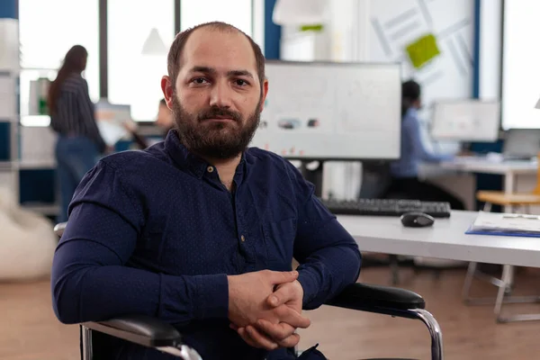 Retrato del empresario paralizado en silla de ruedas mirando a la cámara — Foto de Stock