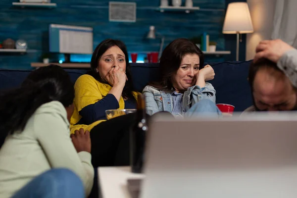 Terrified scared group of people watching horror scary movie on laptop