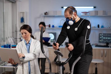 Üzerinde elektrot sensörü olan koşucu modern laboratuarda tıbbi çalışma yapıyor.