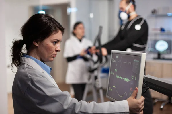 监测器上分析心率脉动的科学家妇女 — 图库照片