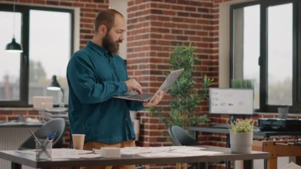 Zaměstnanec drží notebook a najít dobré zprávy o podnikání — Stock video